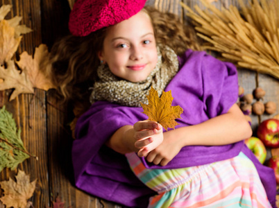 儿童女孩明亮的软针织帽子贝雷帽。秋季时尚针织辅料。针织帽子趋势下降季节。女孩躺在木背上落下叶子的顶部景色。针织配件时尚细节