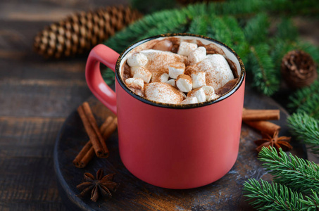 热巧克力与棉花糖在乡村木制背景。 圣诞概念装饰杉树枝和锥。