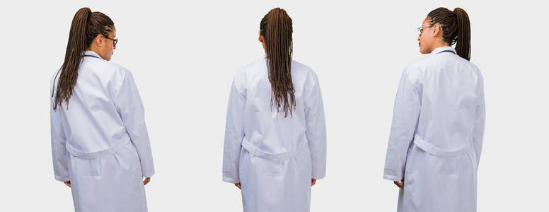 一组年轻的黑人女医生站在灰色背景的后视镜上