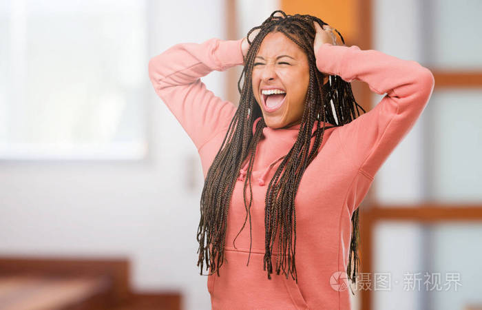 一个穿着辫子的年轻黑人女人的肖像疯狂而绝望地尖叫