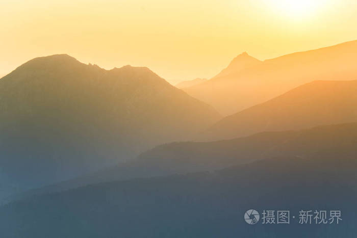 日出中美丽多彩的抽象山景早晨以蓝色色调呈现的山脉极简主义景观