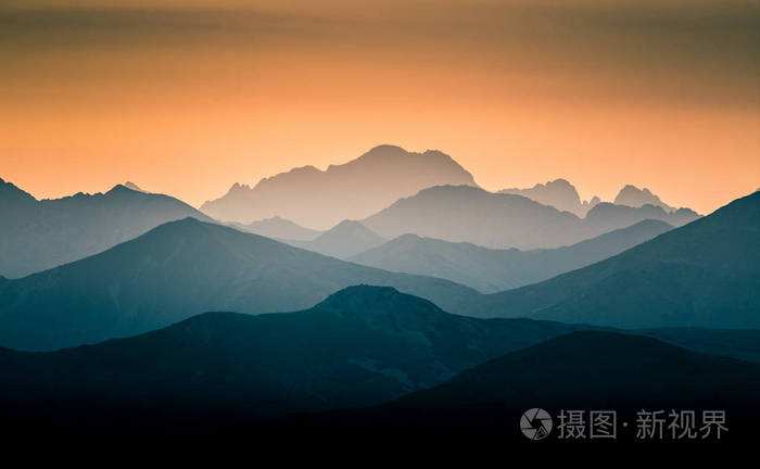 日出中美丽多彩的抽象山景 早晨以蓝色色调呈现的山脉极简主义景观.