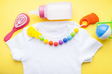 s shoes and toys on yellow background. Newborn. Top view