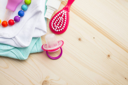 s shoes and toys on white wooden boards background. Newborn. Top