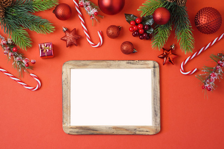 圣诞节背景与相框装饰和装饰在红色桌子上。 顶部视图从上面。 平躺着