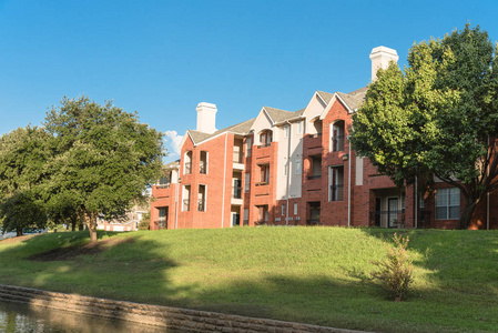 典型的多层河畔公寓楼综合体，周围是成熟的树木，在欧文得克萨斯州美国。