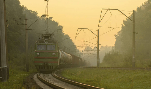 清晨，当雾在街上时，货运火车坐在铁轨上。