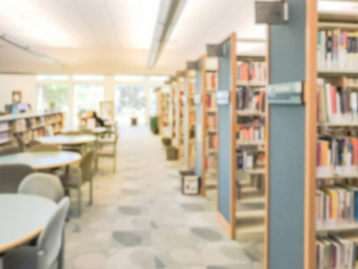 美国德克萨斯州公共图书馆书架和阅览桌的模糊图像通道。继续教育概念。