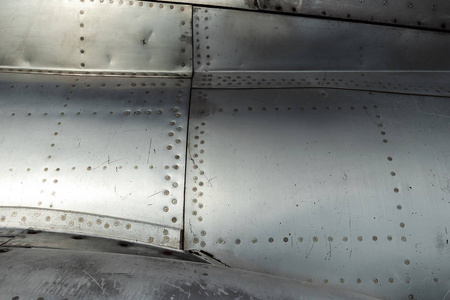 纹理铝机身和铆钉在旧飞机上。 旧技术。