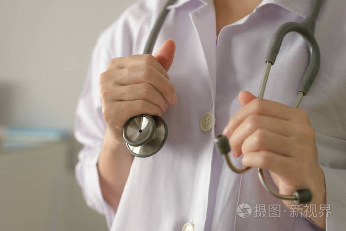 关闭女医生站立和拿着听诊器检查病人的复制空间