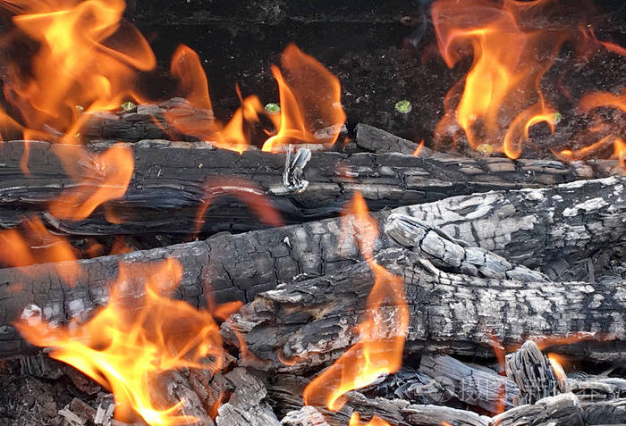 木头在明亮的黄色火焰上燃烧. 烧火准备烹饪烧烤.