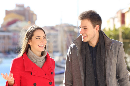 一对幸福的夫妇在一个沿海城镇的冬天谈话的正面肖像