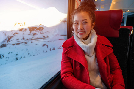 年轻女子坐在火车上看风景。