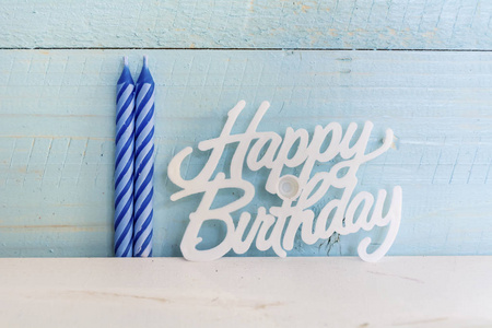 生日快乐蜡烛隔离在蓝色木制背景上
