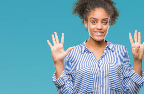 年轻的非洲美国妇女在孤立的背景显示和指着第九个手指，同时微笑自信和快乐。
