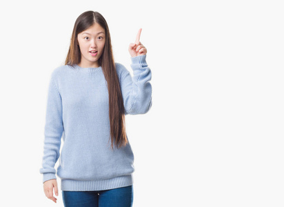 年轻的中国女人在孤立的背景下，用手指着成功的想法。 退出并快乐。 一号。