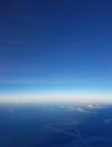在南美洲上空飞行的飞机视图，云层在亚马逊森林之上。