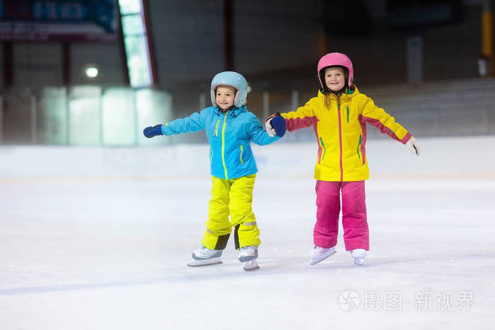 孩子们在室内溜冰场滑冰儿童和家庭健康冬季运动有冰鞋的男孩和女孩