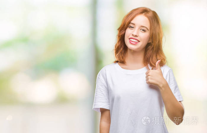 年轻漂亮的女人在孤立的背景下,用手做快乐的竖起大拇指的手势.