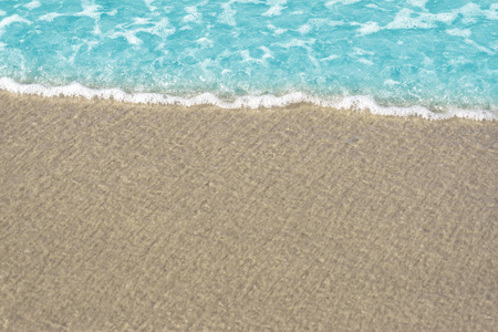 沙滩上蓝色海洋的软波。 背景沙滩和波浪在海滩背景。 在底部放置文本和其他的空间。