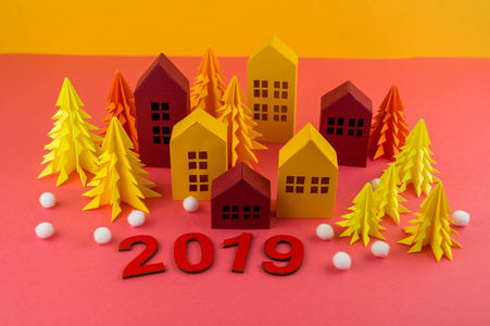 用纸做的圣诞森林。 一栋房子和一棵圣诞树。 雪球。 粉红色和黄色。