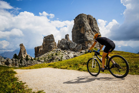 Ampezzo, stunning rocky mountains on the background. Woman ridin