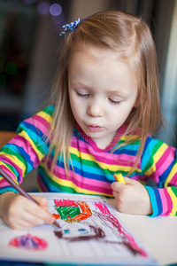 可爱的小女孩一边用铅笔画画