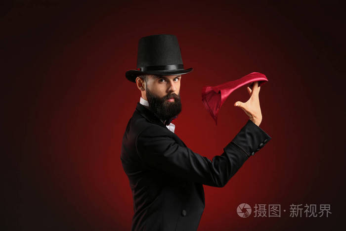 魔术师在黑暗的背景上表演魔术