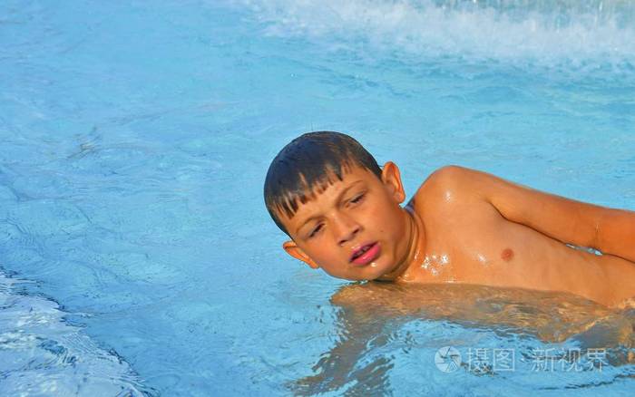 游泳池里小男孩的肖像. 阳光明媚的夏日. 夏天和快乐的童年概念.