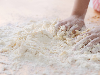 s hands mixing flour and egg on table, to processing dough and l