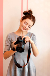 年轻女性摄影师的肖像，微笑着拿着她的相机