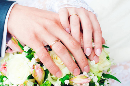 新娘和新郎带结婚戒指和新娘花束