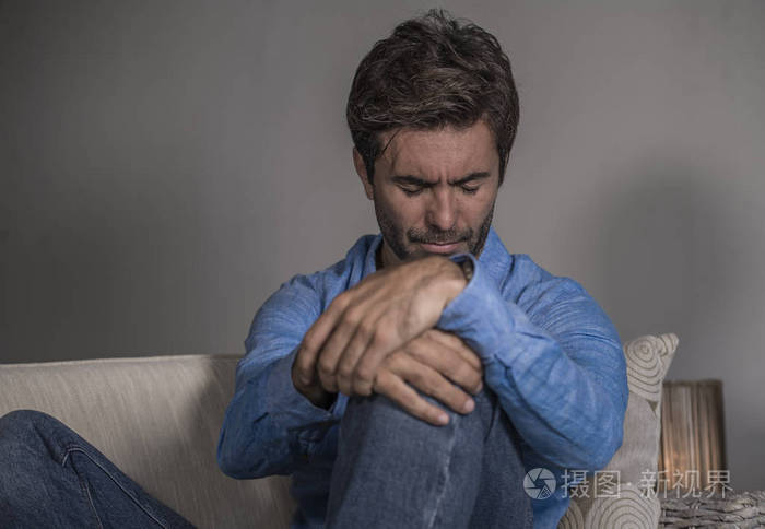 生活方式肖像年轻,有魅力,英俊,悲伤的拉丁男人,疲惫和沮丧地坐在家里