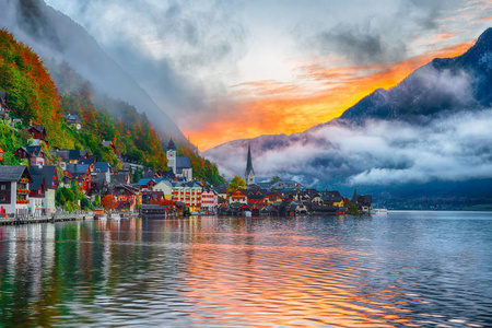 著名的哈尔斯塔特山村与哈尔斯塔特湖的风景。 雾蒙蒙的秋季日出在霍尔斯塔特湖。 地点度假村Hallstatt Salzkamme