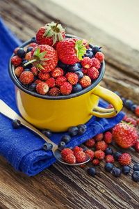 新鲜蓝莓草莓和野生草莓装在表面的杯子里