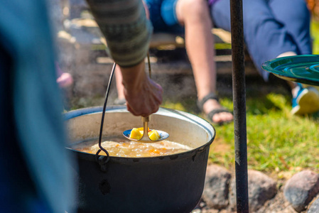 在篝火上用锅煮食物。 夏季野营概念。