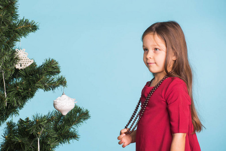 蓝色背景圣诞树的小女孩