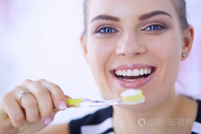 保持口腔卫生的年轻漂亮女孩牙刷