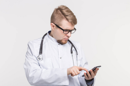 男性医生的肖像在手上的白色背景智能手机