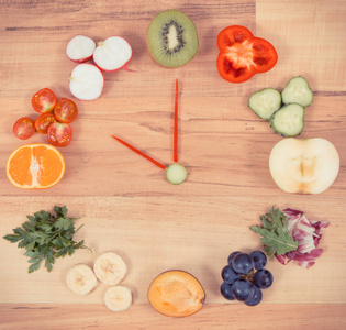 新鲜成熟的水果和蔬菜，以时钟的形状，健康饮食的时间概念，含有天然维生素和矿物质