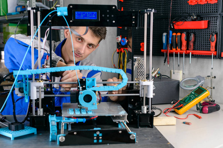 青年设计师工程师在实验室技术和创新理念中使用3D打印机