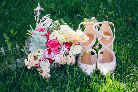 s bouquet and shoes on the grass. Wedding accessories.