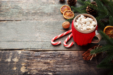 卡布奇诺，杯子里有棉花糖，放在木桌上，上面有圣诞装饰