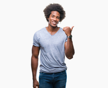 美国黑人男子在孤立的背景上微笑，快乐的脸，看和指向一边，拇指向上。