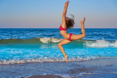 夏季海滩蓝色海岸的杂技体操比基尼女郎