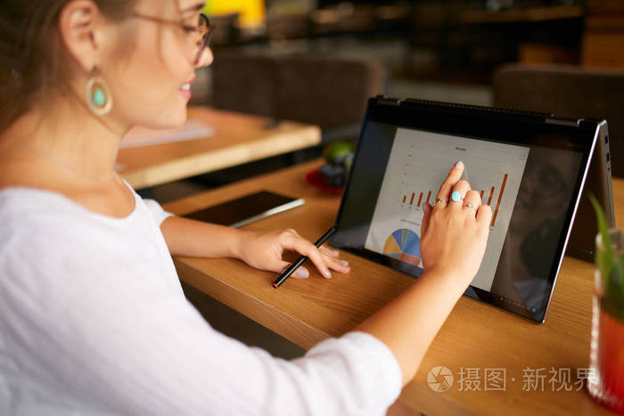 自由职业者的妇女使用2在1笔记本电脑触摸屏工作的业务演示文稿.