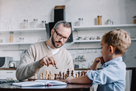 爸爸和可爱的小儿子一起在家下棋