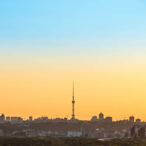 带有电视塔和建筑物轮廓的城市日落