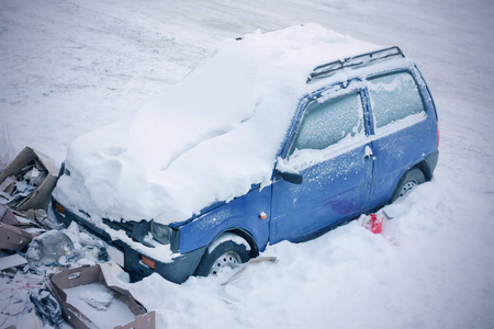 垃圾桶附近积雪覆盖的汽车的俯视图。 色调