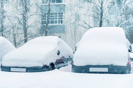 雪中的汽车停在房子的院子里